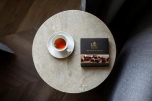 un tavolo con una tazza di tè e un libro di Boutique Hotel Piedra Rome City Centre a Roma
