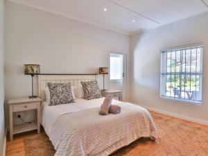a bedroom with a bed with a teddy bear on it at Stanford Stoepe in Stanford