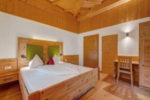a bedroom with a large white bed with a desk at Thalerhof Appartement Verena in Verano