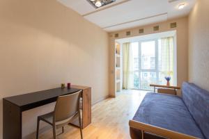 a bedroom with a bed and a desk and a table at Central District Apartments in Kharkiv