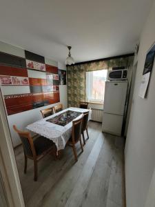 una cucina con tavolo, sedie e frigorifero di Velo Domki i Pokoje NadZamkiem a Czorsztyn