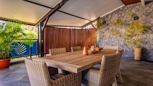 a dining room with a wooden table and chairs at Les 3 sables, CAPUCIN in L'Étang-Salé les Bains