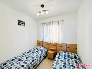 a bedroom with two beds and a window at Faro del Mediterráneo in Cabanes