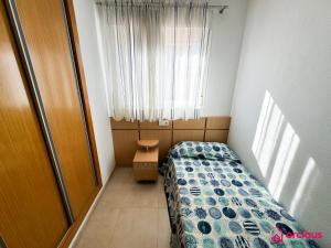 a small bedroom with a bed and a window at Faro del Mediterráneo in Cabanes