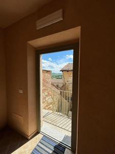 a door to a balcony with a view of a building at Living Monferrato in Cella Monte +8 photos