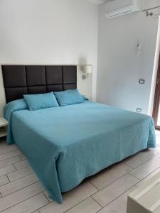 sypialnia z dużym łóżkiem z niebieską kołdrą w obiekcie Zara w mieście Corigliano Calabro +4 zdjęcia