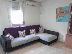 un sofá púrpura con almohadas en la sala de estar en Casa Baleso, en Deltebre