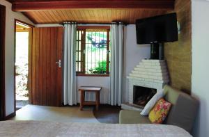 - un salon avec une cheminée et un lit dans l'établissement Hotel Daniela, à Penedo