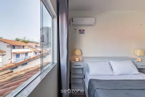 ein kleines Schlafzimmer mit einem Bett und einem Fenster in der Unterkunft Casa Espaçosa 300m da Praia do Peró - VVP0027 in Peró