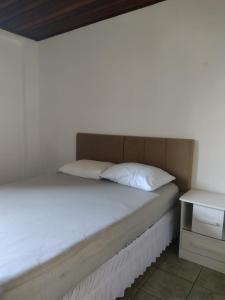 een bed met een hoofdeinde en een nachtkastje naast een bed bij Armação - Florianópolis - 2 quartos de casal in Florianópolis +6 foto's