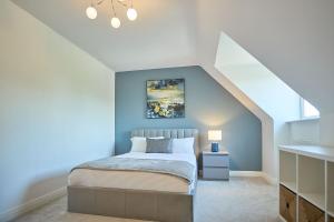 Un dormitorio con una cama y una pared azul. en Host & Stay - Danford Court, en Solihull