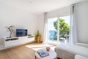 カレリャ・デ・パラフルジェリにあるPrecioso apartamento en primera línea de mar en Calella de Palafrugellの白い部屋(ベッド1台、大きな窓付)