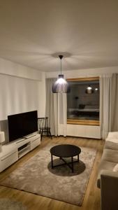 a living room with a couch and a coffee table at Arctic Jaakko Suite in Rovaniemi