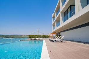 a swimming pool next to a building with a bridge at Portimão Ocean Breeze With Pool by Homing in Lagoa