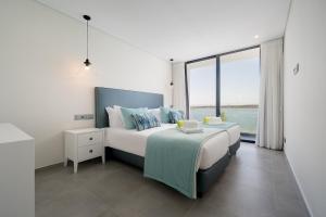 a bedroom with a large bed and a large window at Portimão Ocean Breeze With Pool by Homing in Lagoa +10 photos