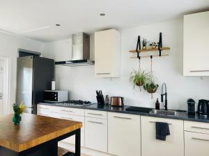 a kitchen with white cabinets and a wooden table at Nature Zeeland in Lamswaarde