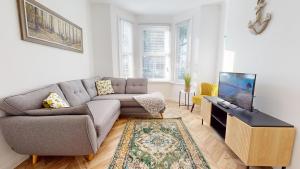 ein Wohnzimmer mit Sofa und Fernseher in der Unterkunft Bright & Spacious 4 Bed Victorian Home by Blue Buzzard Property in Kent