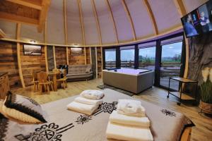 a room with a tub and some towels on a bed at Tatry Mountain Glamp z jacuzzi in Zakopane