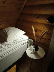 a bedroom with a bed and a table with a vase on it at Vähäreinari, mökki Ylläksellä in Ylläsjärvi