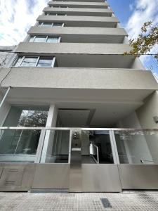 a tall building with a walkway in front of it at Depto Zona Plaza Paso con opcion de Cochera byLofter in La Plata