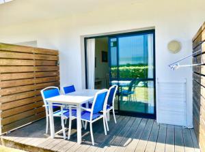 a table and chairs on a deck with a balcony at Caporizon-l'Archipel-T1-Piscine-centre ville-Terrasse in La Rochelle