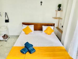 a bedroom with a bed with yellow and white at Kumudu Holiday Home in Hiriketiya +61 photos