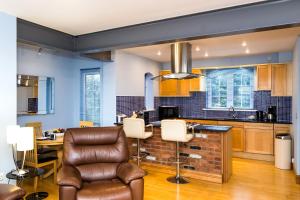 a kitchen with a couch and chairs in a room at The Wharf - Marina Retreat in Pevensey