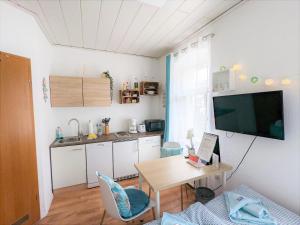 a living room with a table and a kitchen at Urlaubsmagie - Ferienwohnung Tautropfen - Garten mit Terrasse & Saisonaler Pool - H2 in Sebnitz