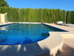 a swimming pool with blue water in a yard at Chalet con piscina in Pinoso