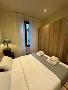 a bedroom with a large bed with towels on it at Emme Loft I First Moon - Exclusive Design Apartment with balcony in Milan