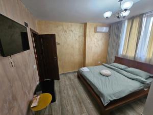 a bedroom with a bed and a flat screen tv at The Bridge House in Balş +3 photos