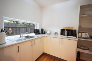 a kitchen with a sink and a microwave at Making Memories - Ocean Grove in Ocean Grove
