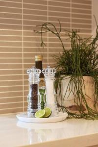 a table with three bottles and a plate with lime slices at Making Memories - Ocean Grove in Ocean Grove