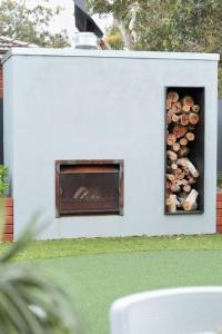 a white building with a pile of logs in it at Making Memories - Ocean Grove in Ocean Grove