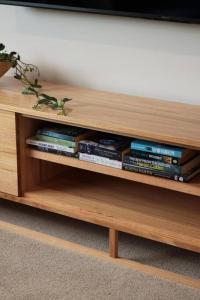 a wooden book shelf with a bunch of books at Making Memories - Ocean Grove in Ocean Grove