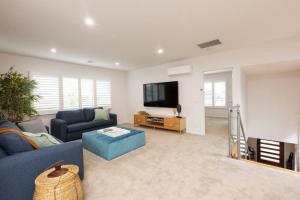 a living room with a blue couch and a tv at Making Memories - Ocean Grove in Ocean Grove
