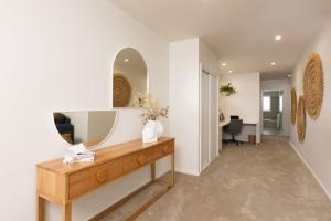 a bathroom with a mirror and a wooden dresser at Making Memories - Ocean Grove in Ocean Grove