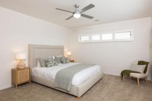 a white bedroom with a bed and a ceiling fan at Making Memories - Ocean Grove in Ocean Grove