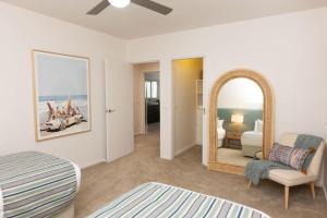 a bedroom with a bed and a mirror and a couch at Making Memories - Ocean Grove in Ocean Grove