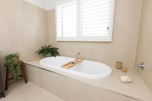 a white bath tub in a bathroom with a window at Making Memories - Ocean Grove in Ocean Grove