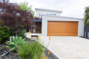 a house with a wooden garage door at Making Memories - Ocean Grove in Ocean Grove
