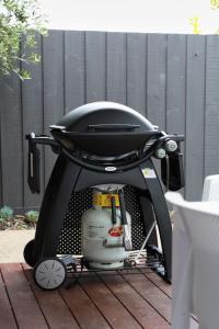 a black stroller with a grill on a patio at Making Memories - Ocean Grove in Ocean Grove
