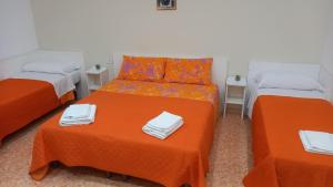 pokój z 2 łóżkami i pomarańczową pościelą w obiekcie B&B Maestra Giovanna w mieście Pompeje +31 zdjęć