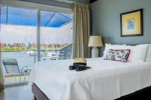 a bed with a hat and a view of a marina at Marina Hotel at Shelter Bay in Colón