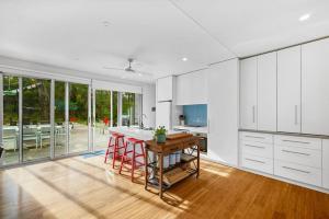 a kitchen with white cabinets and a wooden table at Aireys Bush Retreat in Aireys Inlet