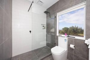 un bagno con wc e doccia con finestra di Ocean View Cottage - Anglesea a Anglesea Altre 21 foto