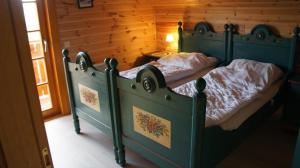a bedroom with two beds and a wooden wall at Charmantes Ferienhaus in Sankt Margarethen Im Lungau mit Kleinem Garten und Bergblick in Sankt Margarethen im Lungau +3 photos