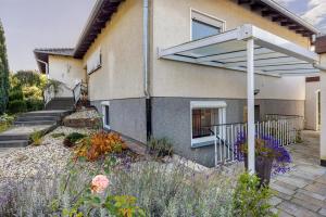 a house with a patio and a white pergola at Ferienwohnung Lilly in Hofgeismar
