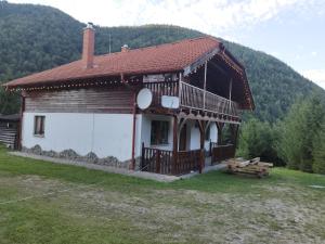 a log house with a porch and a balcony at Cottage Piatra Craiului in Zărneşti