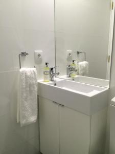 een badkamer met een witte wastafel en een spiegel bij Clerigos-H in Porto